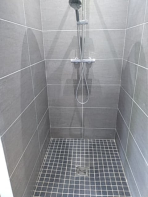 Pose de carrelage sur les murs et sol d'une douche à l'italienne