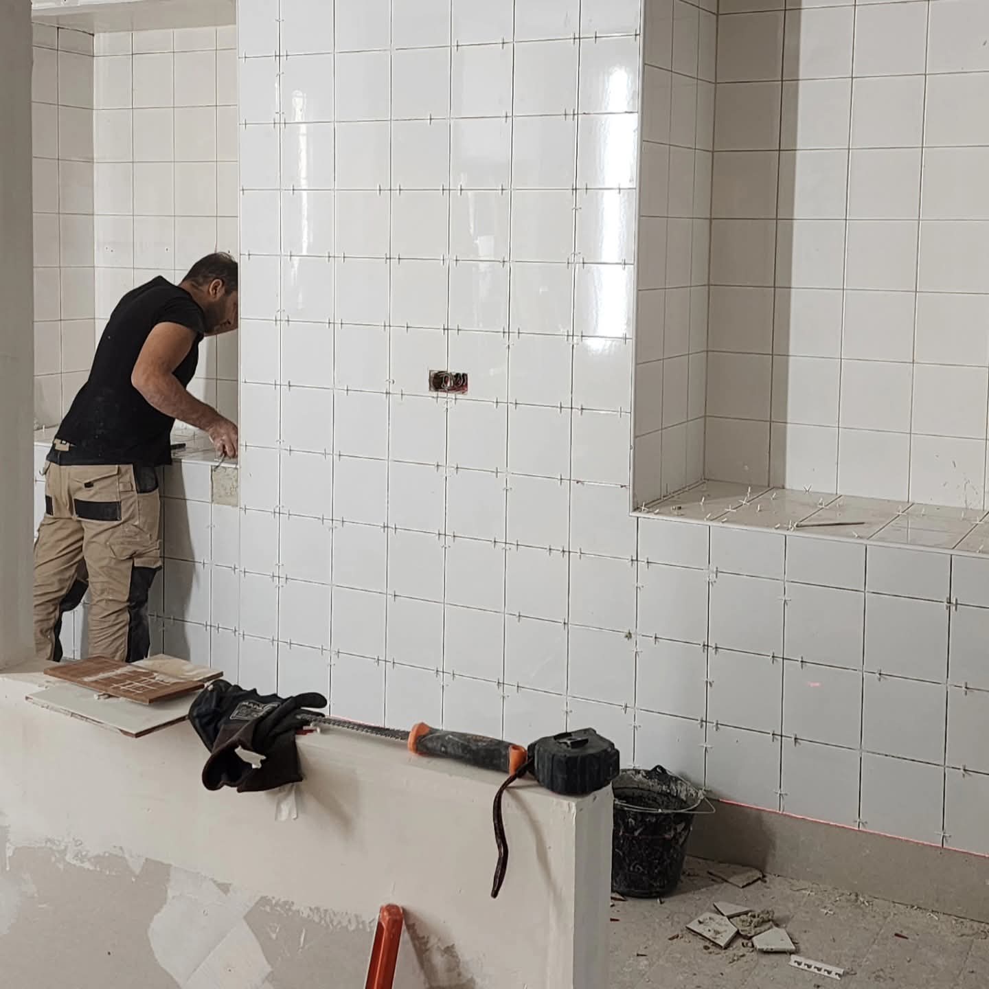 Pose de carrelage mural dans la cuisine d'un restaurant